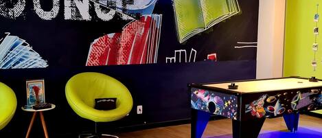 Una habitación con mesa de billar, luces de neón y una pared decorada con temática de Star Trek.
