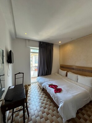 A hotel room with a bed, a desk, a chair, and a television. - Hotel Astoria (Tangier)