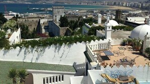 A rooftop terrace with a pool, white domed structures, and a view of a coastal cityscape. - Hotel Astoria (Tangier)