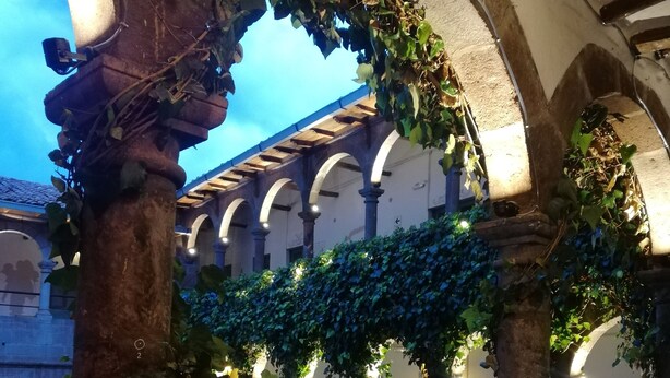 An outdoor courtyard with arches, stone walls, and climbing plants. - Pariwana Hostel Cusco - Adults only (Cusco)