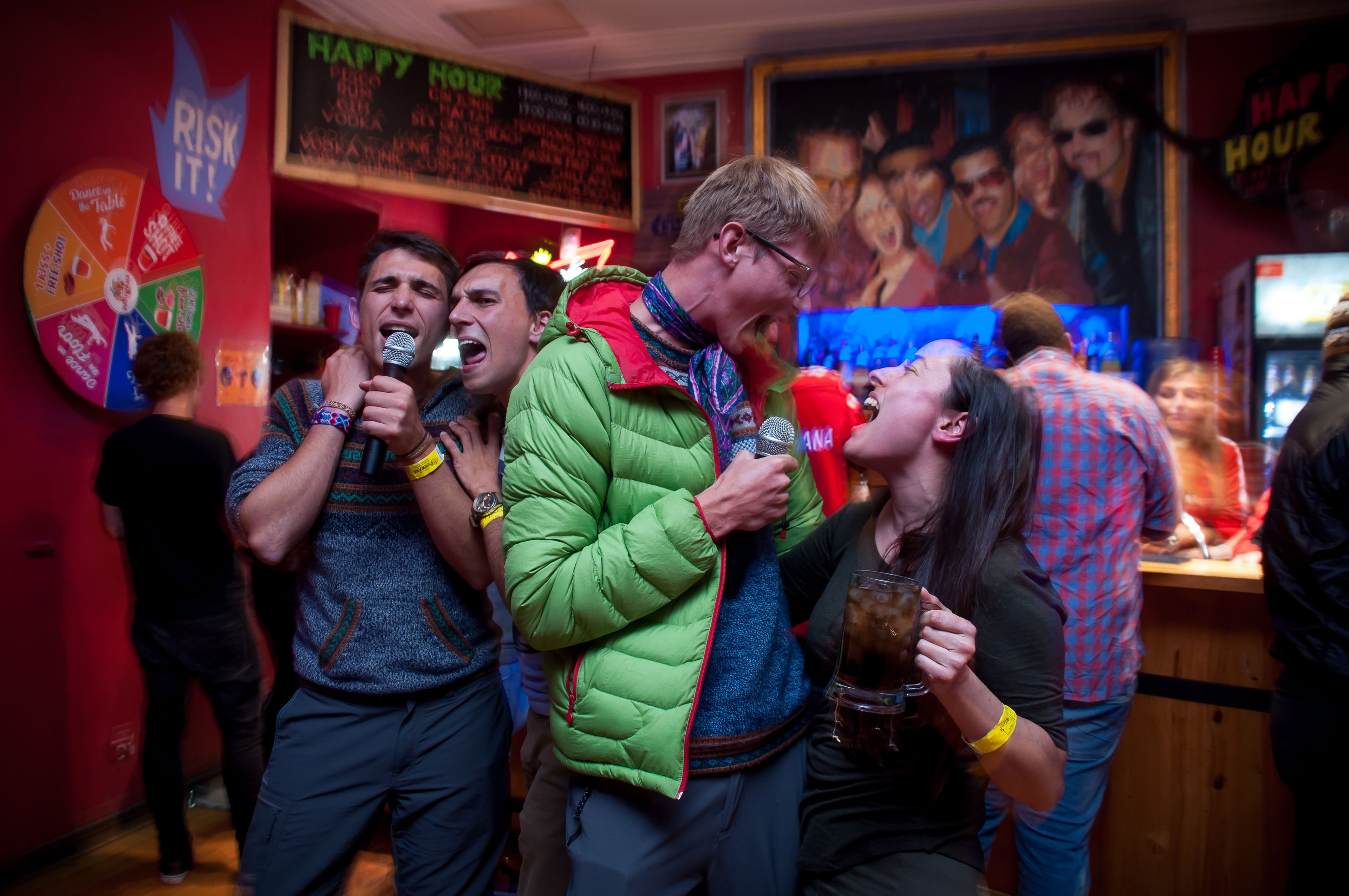Eine Gruppe von Menschen in lebhafter Innenraumgestaltung, vielleicht einer Bar oder einem Club, mit einer dynamischen Atmosphäre.
