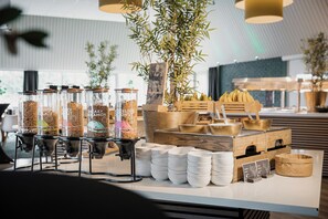 A buffet setup with food dispensers, bowls, and a wooden display. - Hotel & Congrescentrum Mennorode (Elspeet)