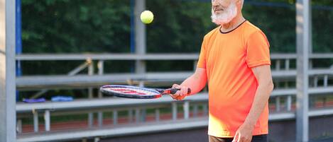 A man holding a tennis racket on a tennis court.