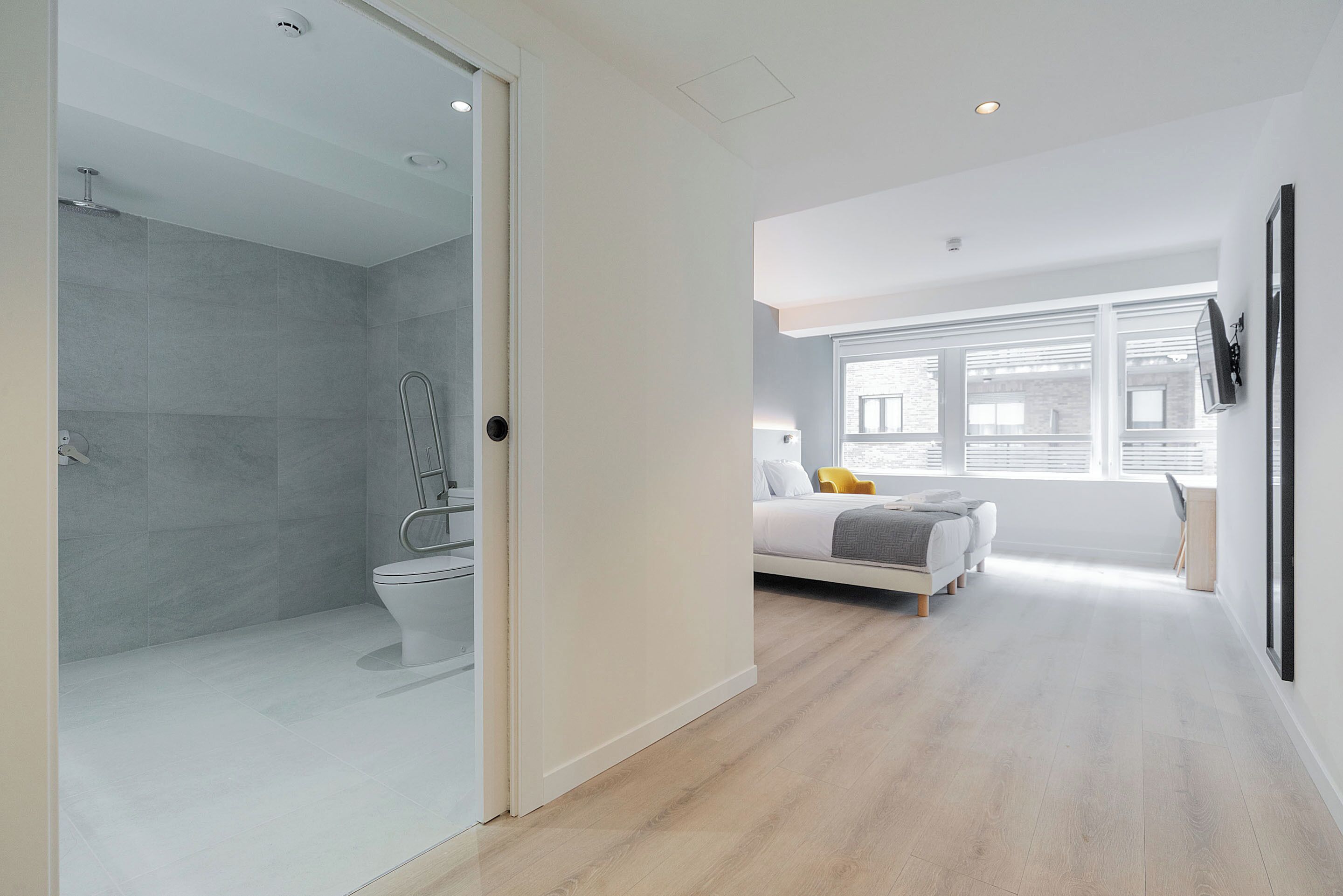 Une chambre moderne avec un lit, une fenêtre et un espace douche.