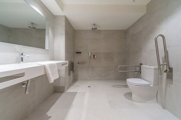 Un baño moderno con ducha, inodoro y lavabo.