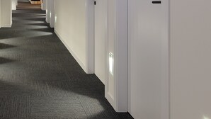 Passadís d'hotel amb sòls de catifes, parets blanques i portes numerades 225.