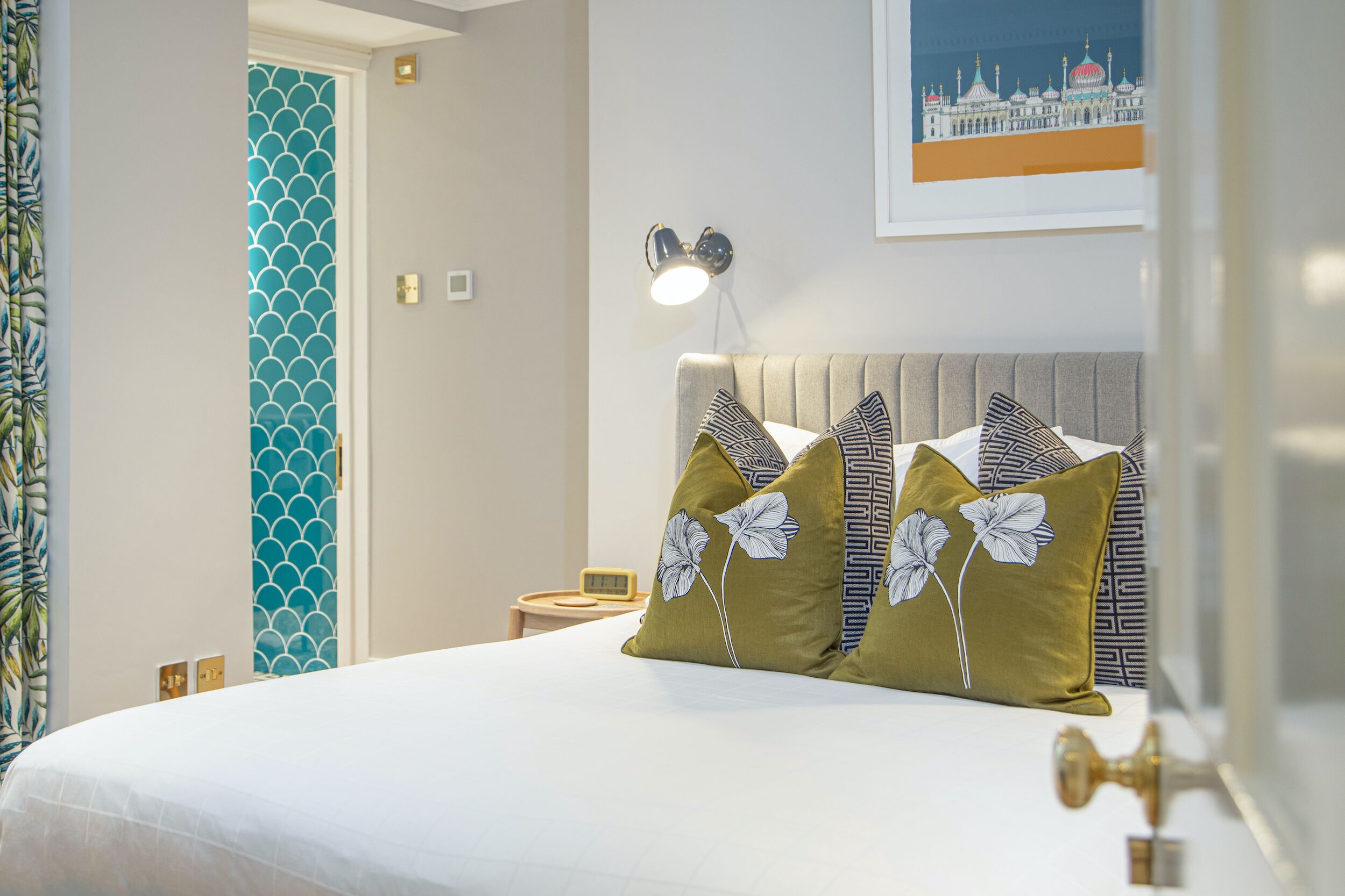 Une chambre d’hôtel avec un lit, une table de chevet, une lampe et un tableau au mur.