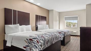 Een hotelkamer met twee bedden, een groot raam en uitzicht op de omgeving.