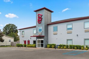 Modernilla designilla varustettu Red Roof Inn -hotelli, jonka tunnusomaisena piirteenä on korkea torni, jossa on kyltit, sekä hyvin hoidettu pysäköintialue ja siisti ulkoasu.