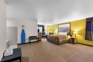 A hotel room with a bed, a desk, a chair, a bathroom, and a large window. - Super 8 by Wyndham Oelwein (Oelwein)
