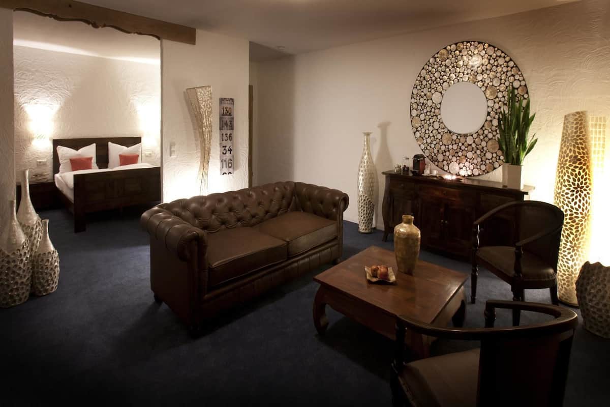 A living room with a brown leather sofa, a wooden coffee table, and a decorative mirror.
