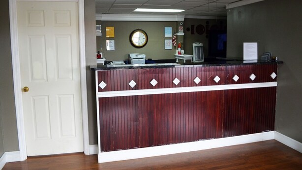A reception desk with a clock, a small American flag, and a bulletin board.