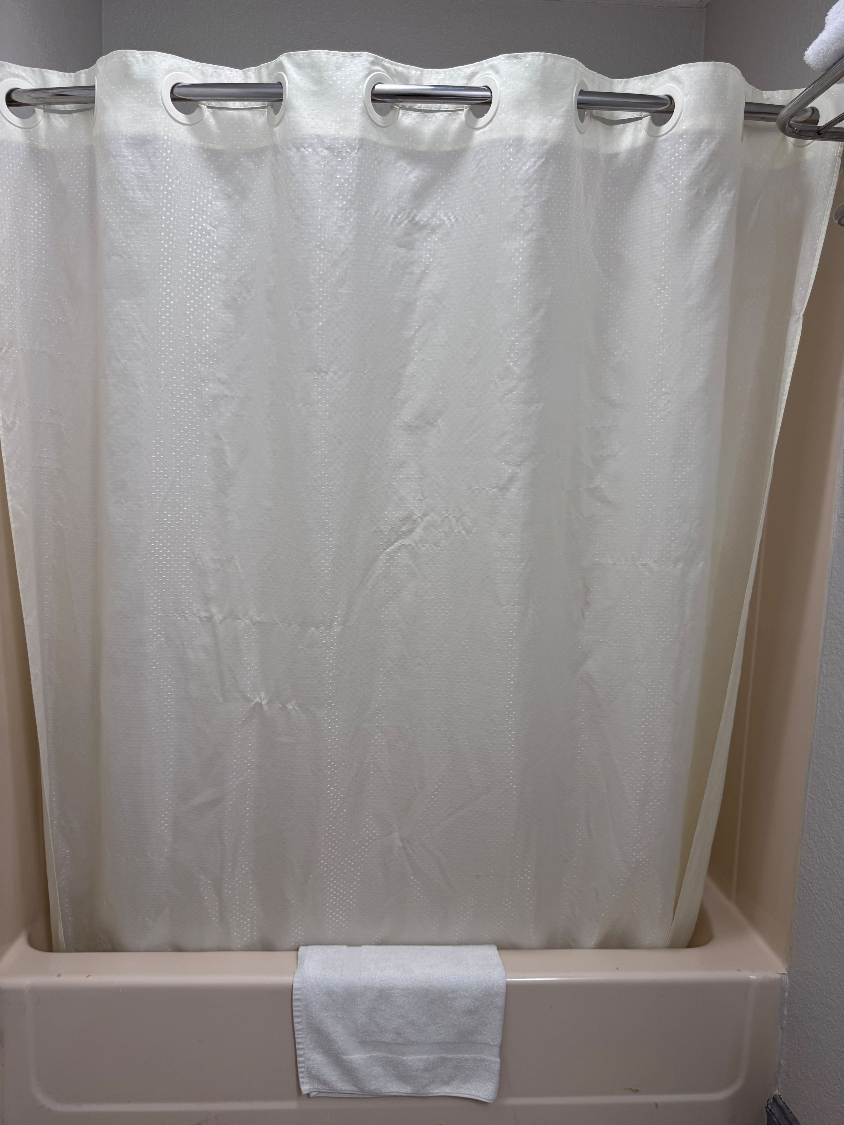 A shower curtain with a handle and a towel hanging on it.