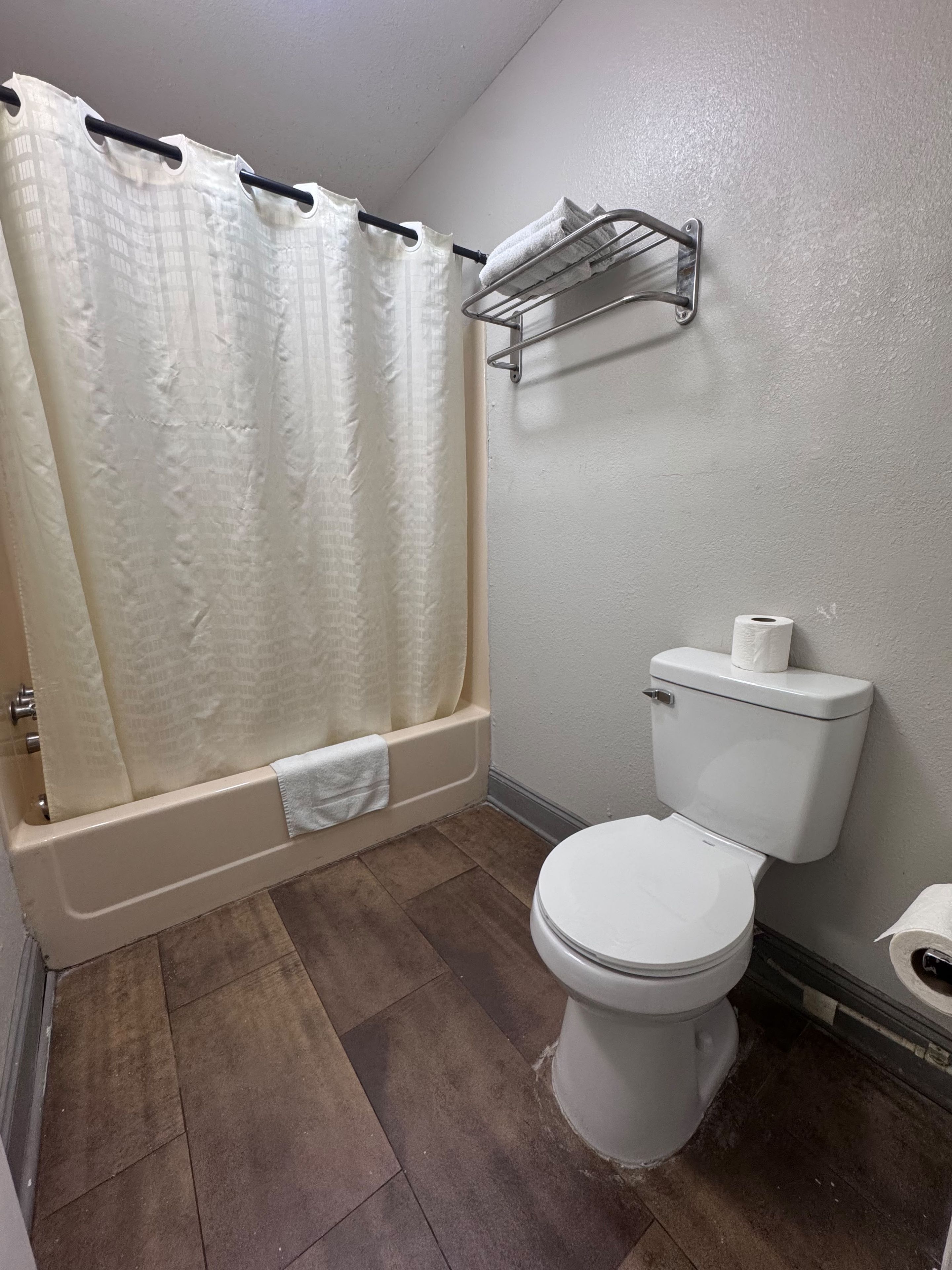 Un baño con bañera, inodoro y cortina de ducha.