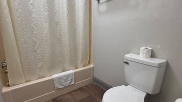 Un baño con bañera, inodoro y cortina de ducha.