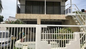 A two-story building with a balcony and a staircase leading to the upper floor. - Casa Bella San Andres (San Andrés)