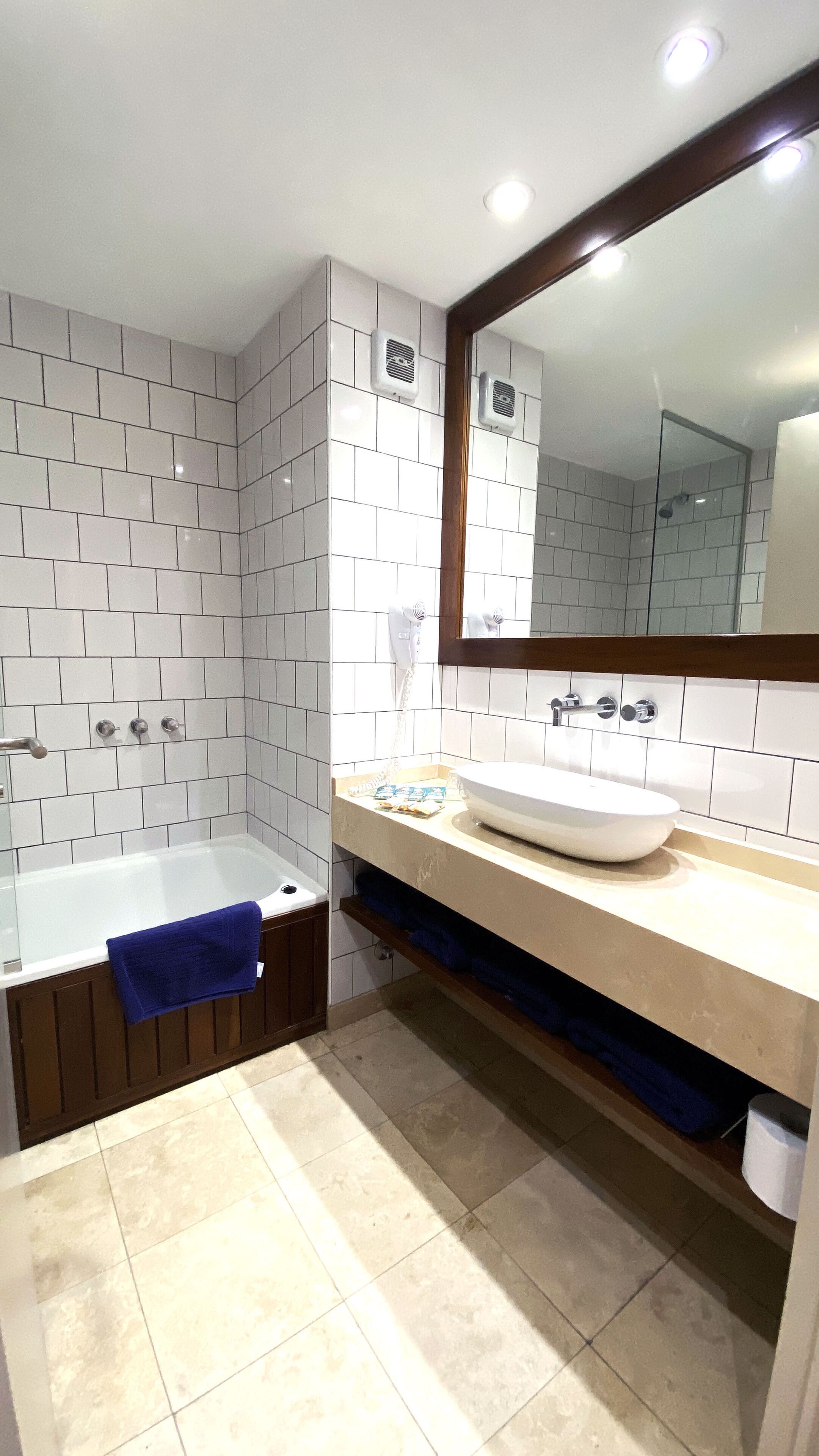 Een badkamer met een bad, een wastafel en een spiegel.