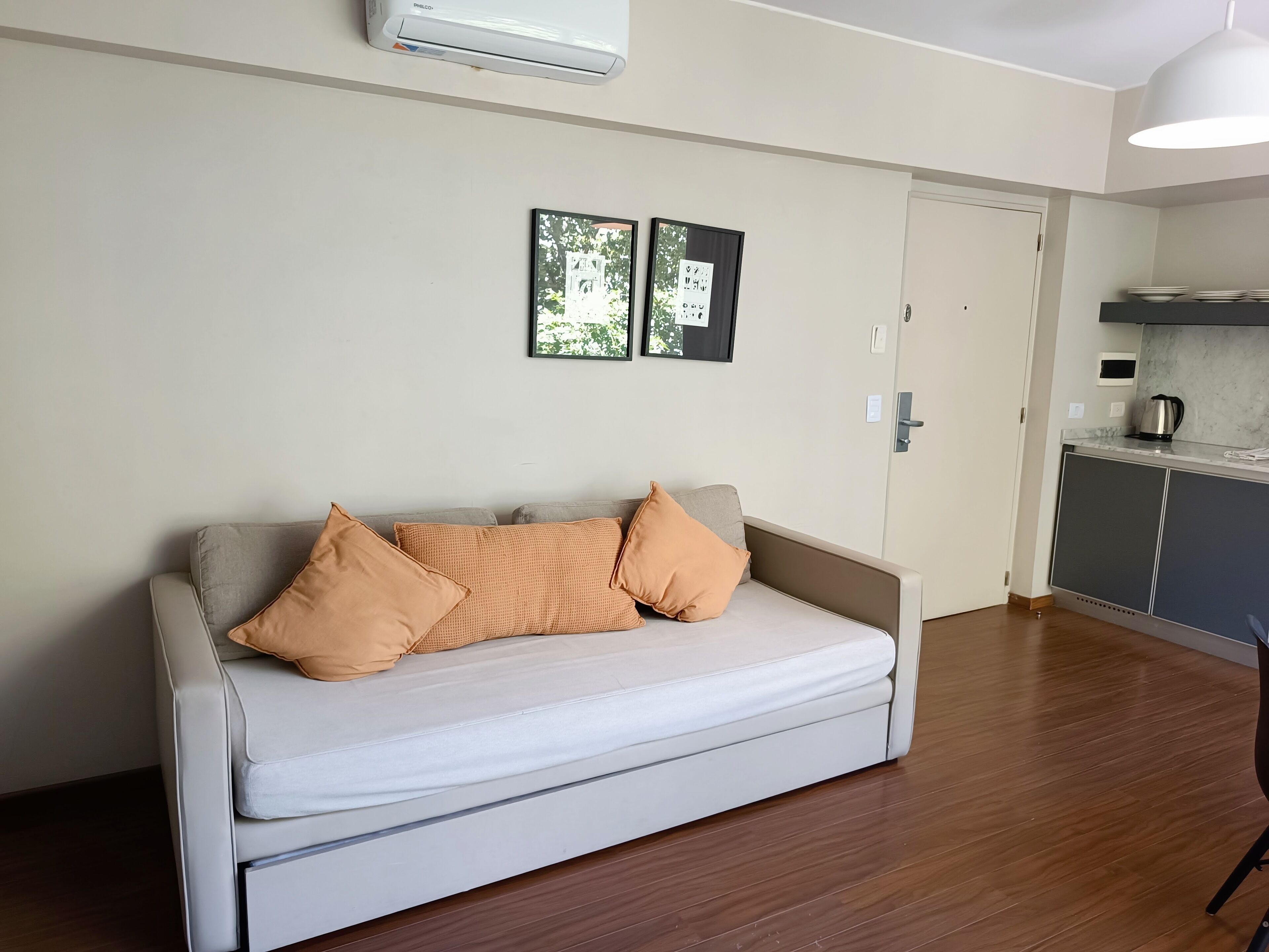 A modern living room with a sofa, a coffee table, and a kitchen area in the background.