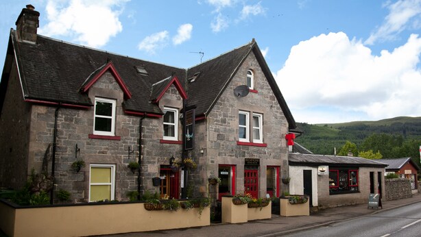 A stone building with red trim, multiple windows, and a signboard. - Richmond House Hotel (Fort Augustus)