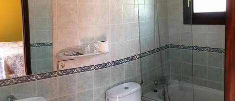 A bathroom with a sink, toilet, and shower.