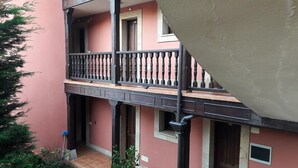 A multi-story building with balconies, a tiled entrance, and a small window. - Hotel Los Ángeles (Cabrales)