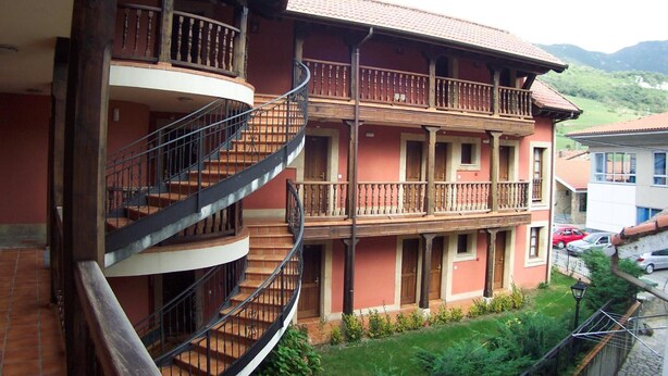 A multi-story building with a spiral staircase and balconies. - Hotel Los Ángeles (Cabrales)