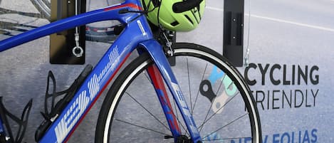 A bicycle with a neon green helmet, parked near a sign that reads "CYCLING FRIENDLY."