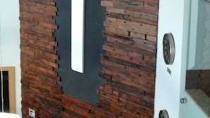 Zona de recepción con pared de ladrillo, un reloj y un mostrador con documentos.