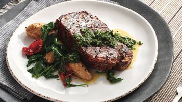 Een bord eten met steak, groenten en geroosterde aardappelen.