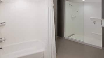 A modern bathroom with a bathtub, a glass-enclosed shower, and a vanity with a mirror.
