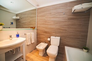 Bañera con ducha, bañera profunda, bidet, toallas
