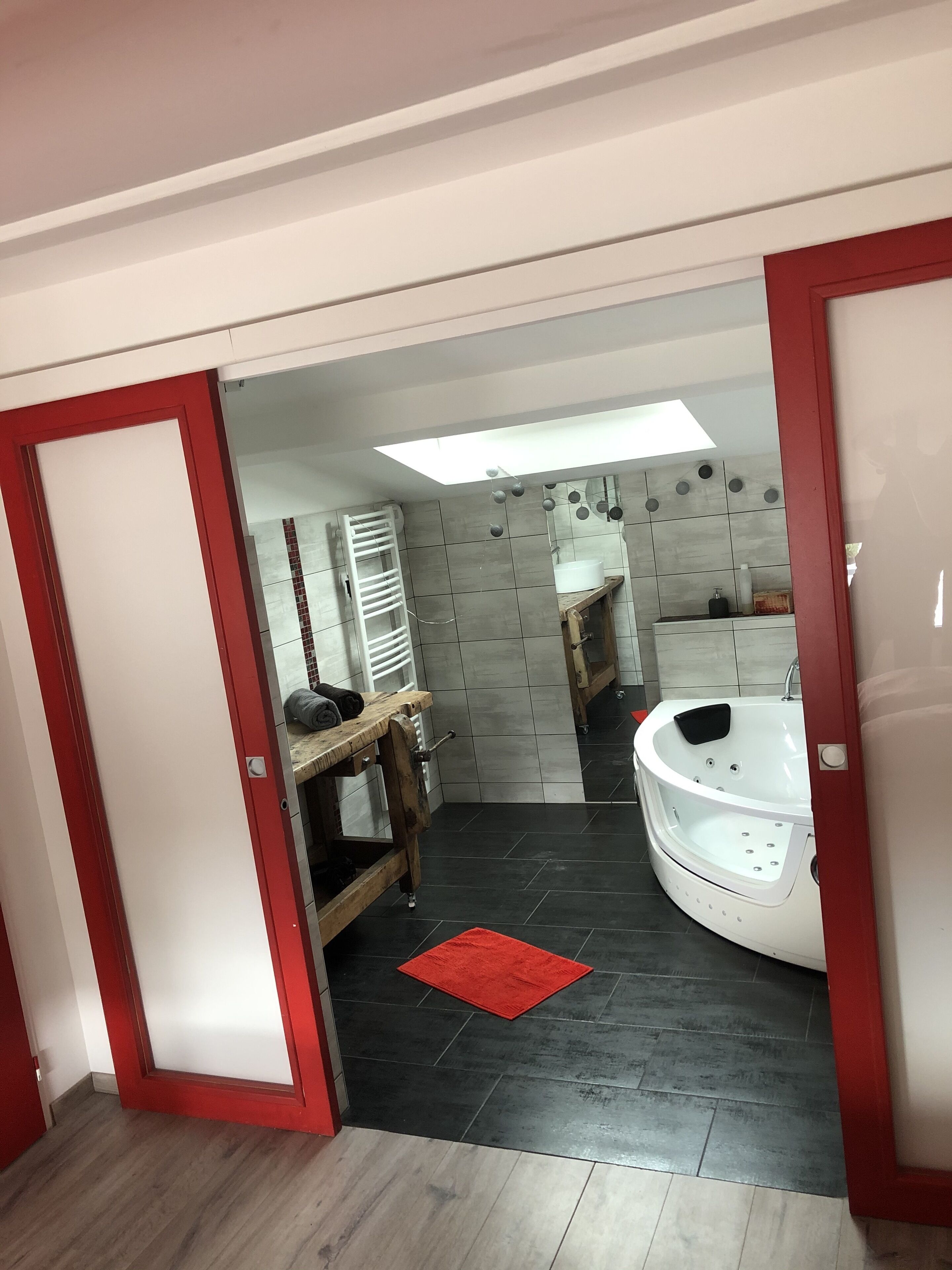A modern bathroom with a bathtub, a vanity, and a shower area.