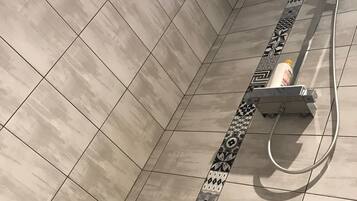 A bathroom with beige tiles and a decorative border.