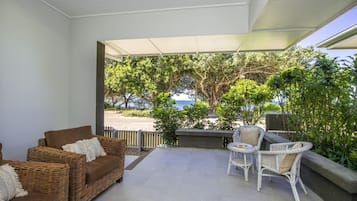 Relax on the balcony with a sofa and two chairs, surrounded by lush greenery and a stunning ocean view.