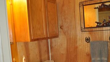 Een bad/douchecombinatie, een haardroger, handdoeken, zeep