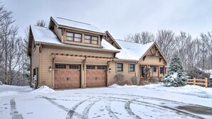 A two-story log cabin with a garage, a covered porch, and a snow-covered landscape. - 2 Mi to Schuss Mtn! Northern Retreat w/ Game Room (Bellaire)