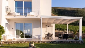 A modern two-story house with a covered patio, outdoor seating, and a view of the surrounding landscape. - Villa Cristina - Relax - Pool and Sea View (Castellammare del Golfo)