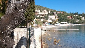 Une zone côtière avec des bâtiments construits sur une colline, une plage et une côte rocheuse.