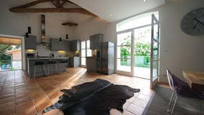 Una cocina moderna con ventanas amplias, una zona de comedor y una alfombra de cuero negro original.