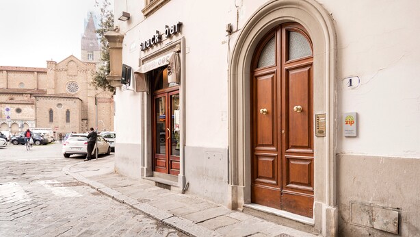 A building with a large wooden door and a sign that reads "Snack Bar." - Zip b&b in Florence (Florence)