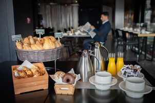 Un bufé de desayuno con pan, bollería y café.