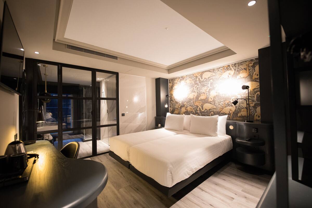 Ein modernes Hotelzimmer mit einem großen Bett, einem Schreibtisch und einer Sitzecke.
