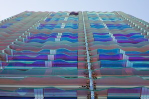 Un edificio moderno con fachada ondulada y varios balcones.