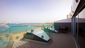 A modern balcony with a glass railing overlooking a beach and marina. - Hotel Silken Saaj Las Palmas (Las Palmas de Gran Canaria)