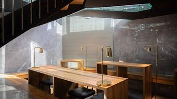 Un intérieur moderne avec un bar en bois, des tabourets de bar noirs et des luminaires suspendus.