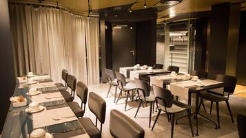 A conference room with multiple tables and chairs, equipped with nameplates and table settings.
