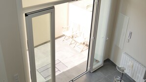 Een moderne kamer met een schuifglazen deur naar een terras.