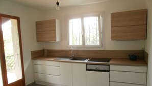 A kitchen with white cabinets, a sink, and a window with curtains. - Air cond. panoramic view, 12x6 swimming pool, diving board, on 2 hectares, quiet (Lorgues)