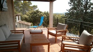 A covered outdoor seating area with wooden furniture and a blue lounge chair. - Air cond. panoramic view, 12x6 swimming pool, diving board, on 2 hectares, quiet (Lorgues)