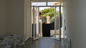 A hallway with a glass door leading to a balcony. - Large chic and modern loft, industrial decor (Beausoleil)